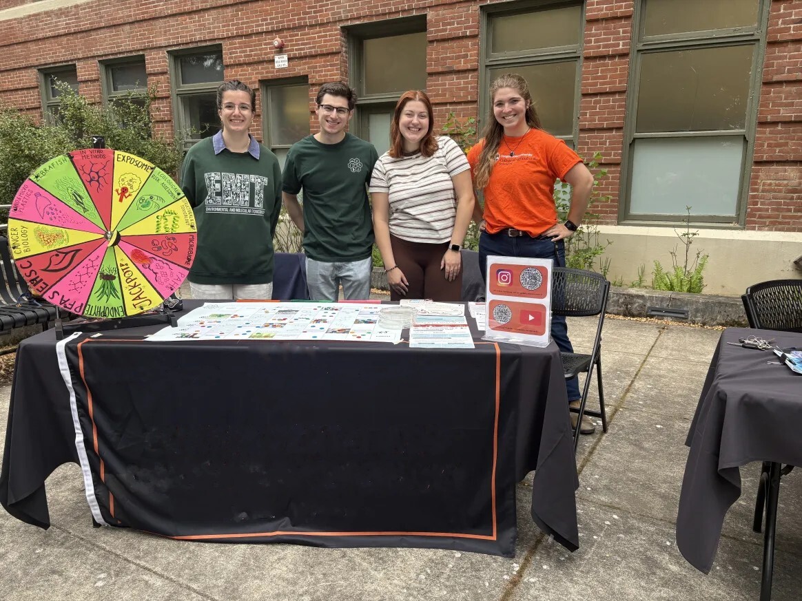 OSU SRP trainees at a community outreach table with the research wheel